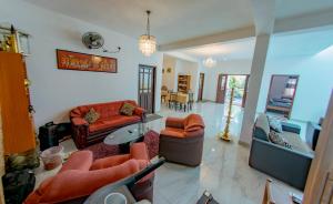 ein Wohnzimmer mit Sofas und einem Glastisch in der Unterkunft Ciel Grand Villa in Kandy