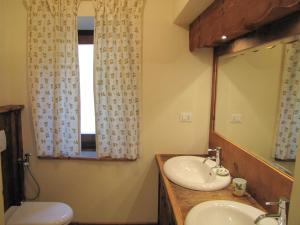 a bathroom with two sinks and a mirror and a toilet at Appartamenti dei Giardini in Courmayeur +16 photos