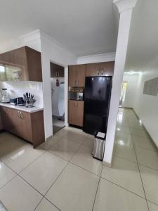 a kitchen with a black refrigerator in a room at Chic Boutique 2BR Apt Walk to Station w/ Parking in Sydney