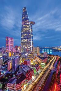 a tall skyscraper in a city at night at Anh Thien Sai Gon Central Hotel - District 1 in Ho Chi Minh City