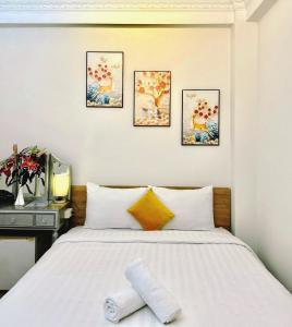 a bedroom with a bed and four paintings on the wall at Anh Thien Sai Gon Central Hotel - District 1 in Ho Chi Minh City