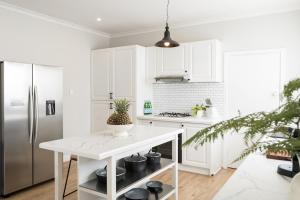 a kitchen with white cabinets and a white counter top at Seafarers Cottage in Capel Sound