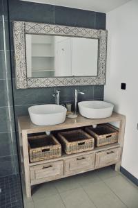 ein Badezimmer mit einem Waschtisch mit 2 Waschbecken und einem Spiegel in der Unterkunft Villa Paul Ermitage in La Saline-Les-Bains