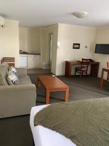 a living room with a couch and a table at Armidale Pines Motel in Armidale
