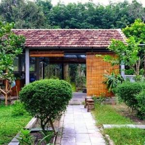 einen Pavillon in einem Garten mit einem Gebäude in der Unterkunft Vườn Nhà Ngoại Garden Homestay in Cu Chi