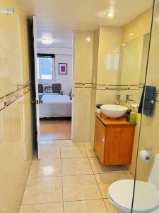 メキシコシティにあるDepartamento en Tehuantepec Romaのバスルーム(洗面台、トイレ付)、ベッド1台が備わります。