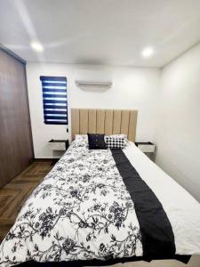 een slaapkamer met een bed met een zwart-witte deken bij * Elegante * Departamento Pitagoras 4 in Ciudad Juárez