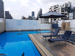 - une piscine sur le toit avec des chaises et un parasol dans l'établissement 2A-2 Bedrooms3Bathrooms Downtown Bangkok Near Mrtbts, à Bangkok