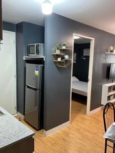 a kitchen with a refrigerator and a door to a bedroom at Condo Rentals in Arezzo - 1 Br Condo in Davao City