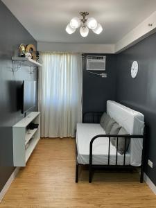 a living room with a bed and a tv at Condo Rentals in Arezzo - 1 Br Condo in Davao City