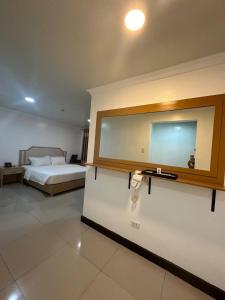 a bedroom with a bed and a mirror on the wall at PUNTA CLARK HOTEL in Clark