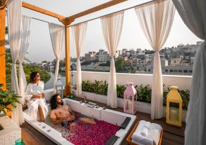 dos chicas sentadas en una bañera en un balcón en Moustache Udaipur Verandah en Udaipur