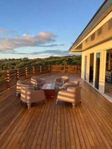 una terraza con sofás, mesa y sillas en Puunui Lodge en Vairao