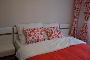 グダニスクにあるApartament Groblaのベッド(赤と白のシーツ、枕付)