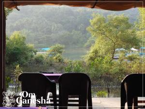 a table with chairs and a view of a river at Om Ganesha in Palolem