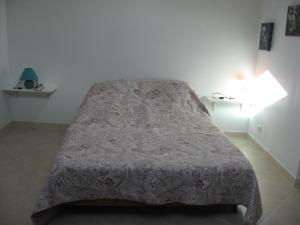 Una cama en un dormitorio con una manta. en T 2 avec velux au 1er étage de 34 m2, en La Londe-les-Maures