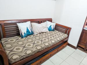 een houten bed met 2 kussens erop bij Skies Condo unit in Moldex Residences Baguio in Baguio