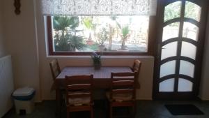 mesa y sillas en una habitación con ventana en Zulu Cafe Apartment en Rétság