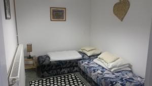 Habitación con 2 camas sentadas junto a una pared en Zulu Cafe Apartment, en Rétság