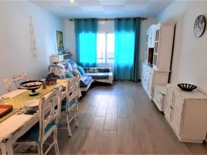 - un salon avec des rideaux bleus, une table et des chaises dans l'établissement Apartamento Llançà, 3 dormitorios, 6 personas - ES-170-84, à Llançà