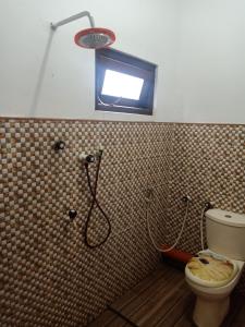ein Bad mit Dusche, WC und Fenster in der Unterkunft Beach Guest House Addalaichenai in Addalachenai