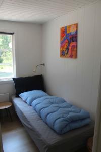 uma cama sentada num canto de um quarto em Charming Cottage Close To The Beach em Vester Sømarken