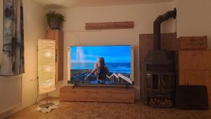 a flat screen tv in a living room with a fireplace at Ferienwohnung Jakob in Neustift im Stubaital