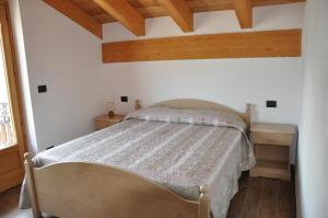 1 dormitorio con 1 cama en una habitación con techos de madera en Le Foyer de la Ferme, en Aosta