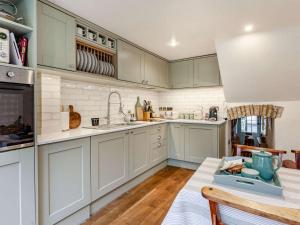 a kitchen with white cabinets and a table with a blue tray at 2 Bed in Minchinhampton 72872 in Minchinhampton