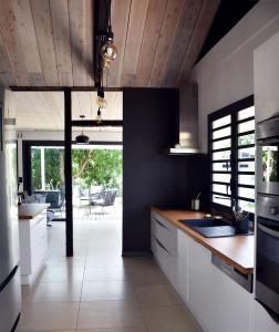 eine Küche mit weißen Schränken und einer Holzdecke in der Unterkunft Villa Paul Ermitage in La Saline-Les-Bains