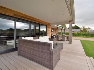 a patio with a couch and chairs on a deck at 4 bed in Oswestry 73291 in Kinnerley