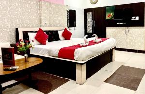 dwa łabędzie siedzące na łóżku w sypialni w obiekcie Hotel Pratap Palace w mieście Bharatpur