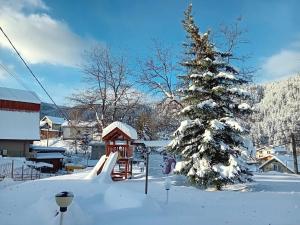 a snow covered yard with a christmas tree and a playground at SA Services private apartments, Eagle Rock complex in Beli Iskar