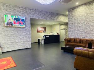 a lobby with a couch and a tv on a brick wall at ホリディパールホテル in Osaka