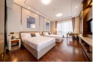 a bedroom with a large bed and a living room at Millenia Executive Apartment - Guangzhou East Railway Station Zhujiang New Town Branch in Guangzhou