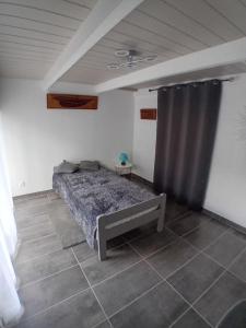 a bedroom with a bed and a curtain at O P Ty logis du Tregor in Pédernec