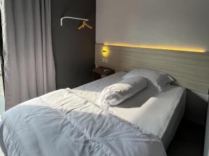 a bedroom with a bed with white sheets and pillows at Kaira Room Guest House Syariah Redpartner in Yogyakarta
