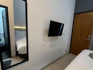a mirror in a hotel room with a bed and a television at Kaira Room Guest House Syariah Redpartner in Yogyakarta