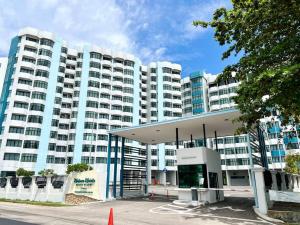 un gran edificio con una gasolinera delante en Puteri Front Beach Resort Studio Melaka 4pax/1park, en Kampong Pantai Dusun