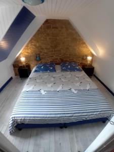 um quarto com uma cama grande e almofadas azuis em O P Ty logis du Tregor em Pédernec
