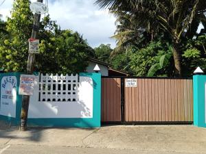 a gate in front of a fence with a wooden gate at Bakery Family Guest House in Mirissa