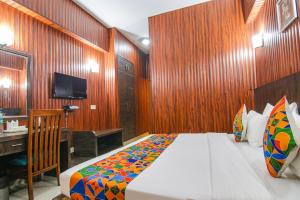 a bedroom with a bed with a wooden wall at FabHotel Prime The Rivlet MG Road in Gurgaon