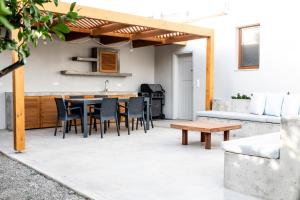 patio con mesa y sillas y cocina en Avli Guest House en Tympáki
