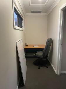 TruganinaにあるCosy Room with Lock, TV & Private Toiletのデスクと椅子、窓のあるオフィス