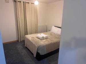 a bedroom with a bed with two towels on it at Best in Purfleet