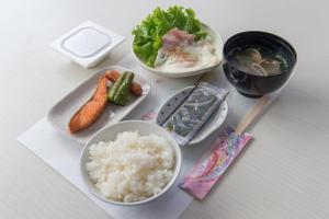 einen Tisch mit drei Schalen Reis und Gemüse in der Unterkunft Yamamoto Ryokan in Fukuoka