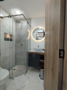 a bathroom with a toilet and a sink and a mirror at Zamá Room Hotel in Medellín