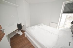 a white bedroom with a bed and a desk at Apartamenty Gdańsk EU - Apartament Nowoczesny Gdańsk in Gdańsk