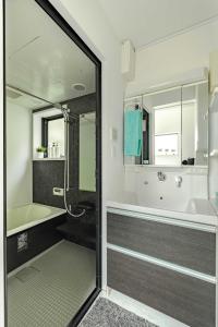 a bathroom with a shower and a tub and a sink at Pencil House - 10 mins walk to Shinjuku in Tokyo