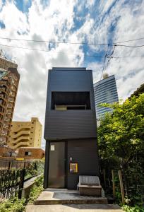 a black house in the middle of a city at Pencil House - 10 mins walk to Shinjuku in Tokyo